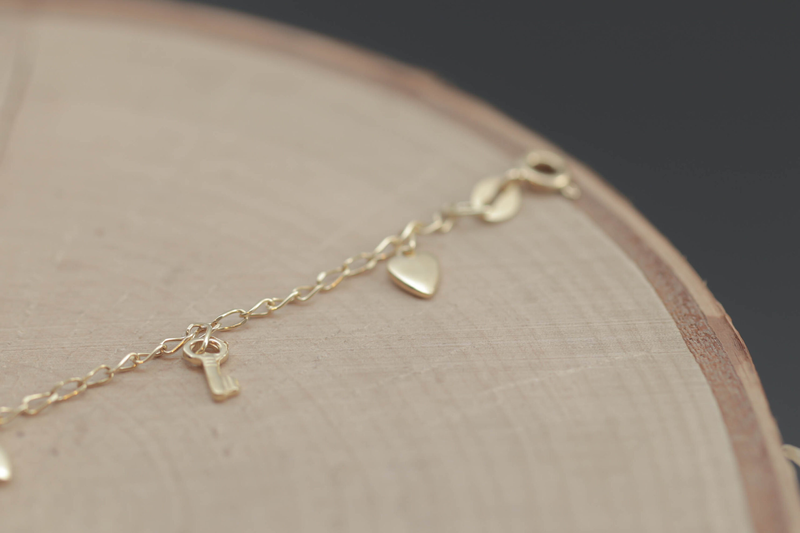 Børne armlænke med charms i 18 karat guld