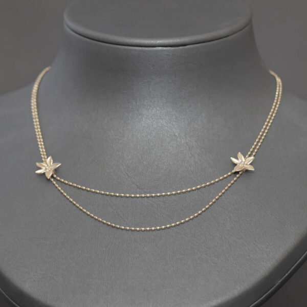 Elegant halskæde prydet med blomster i 14 karat guld