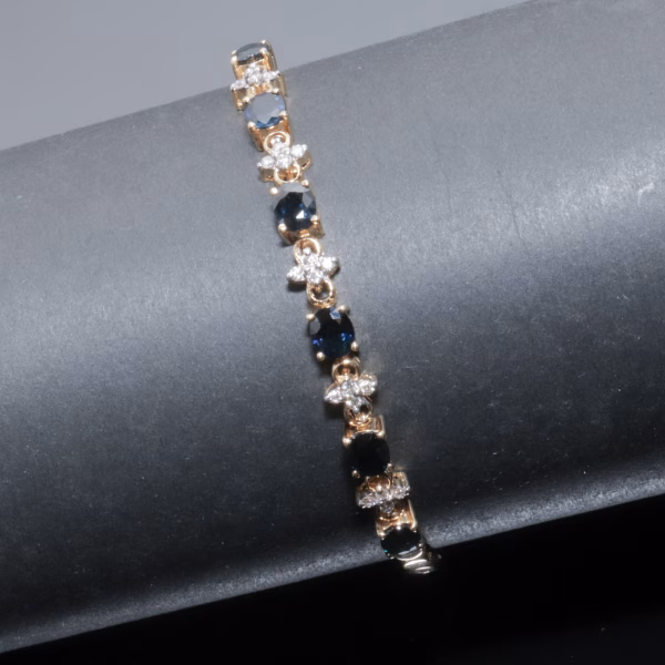 Armbånd med diamanter og blå safirer i 18 karat guld